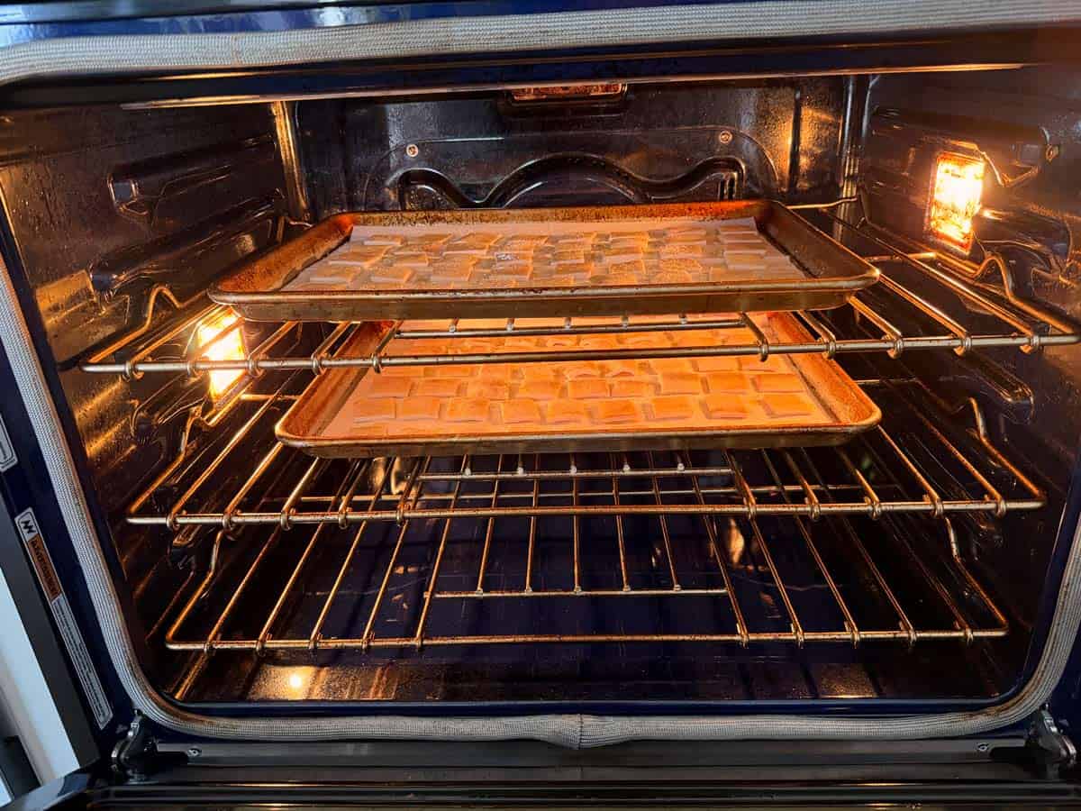 Two pans of pork rinds are baked together.
