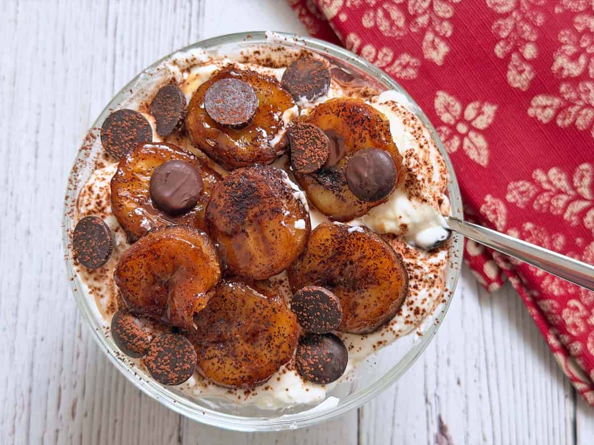 Greek yogurt is topped with fried bananas and chocolate chips.
