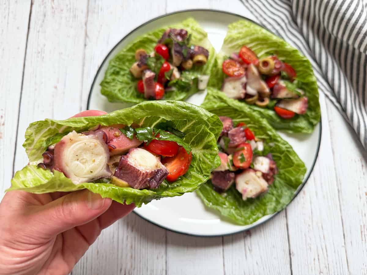 Octopus salad is served in a lettuce wrap.