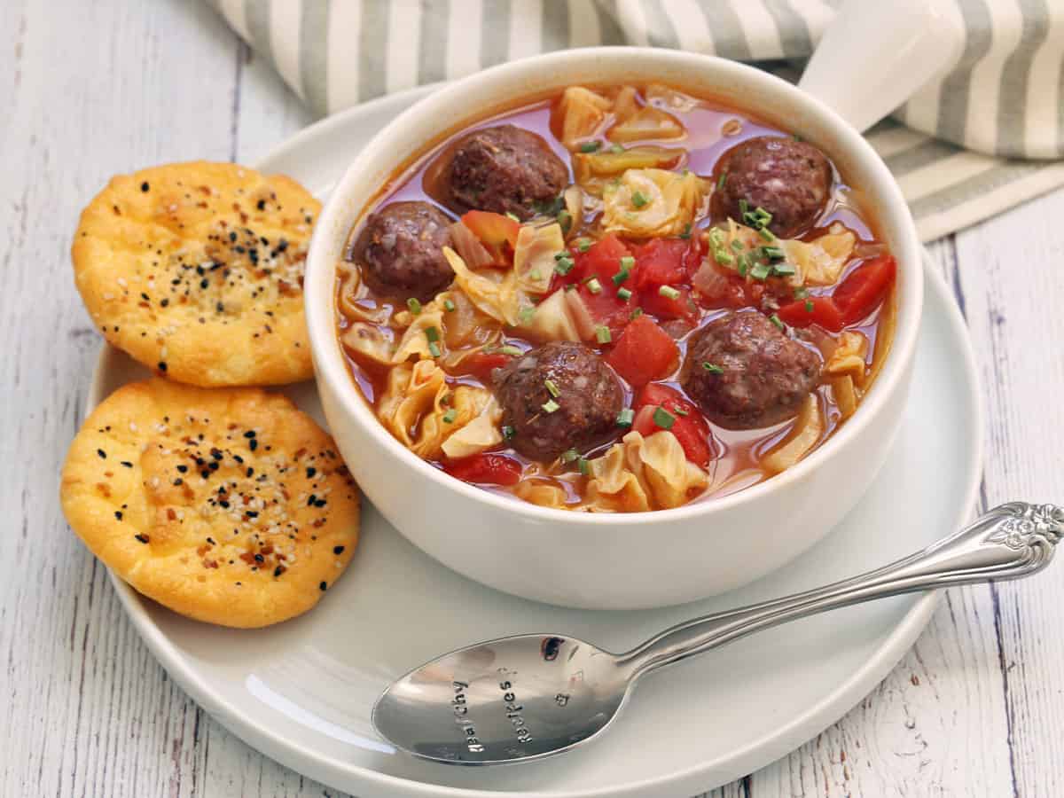 Cabbage soup with meatballs is served with a side of cloud bread.