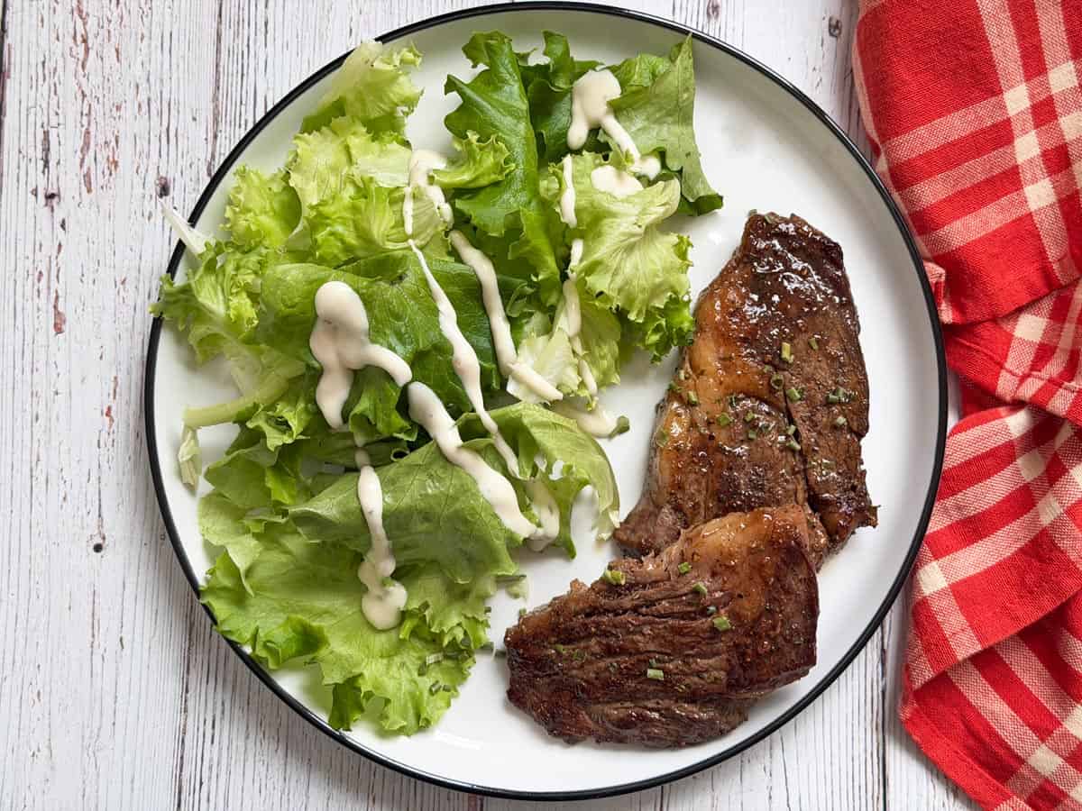 Chuck eye steak leftovers are served with a salad.