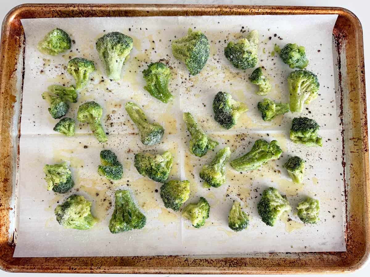 Frozen broccoli is arranged on a baking sheet.