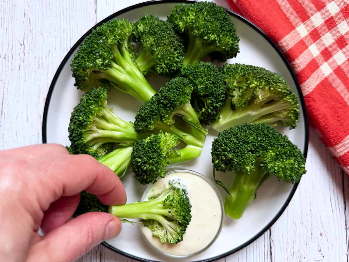 Microwave broccoli is dipped into blue cheese dressing.