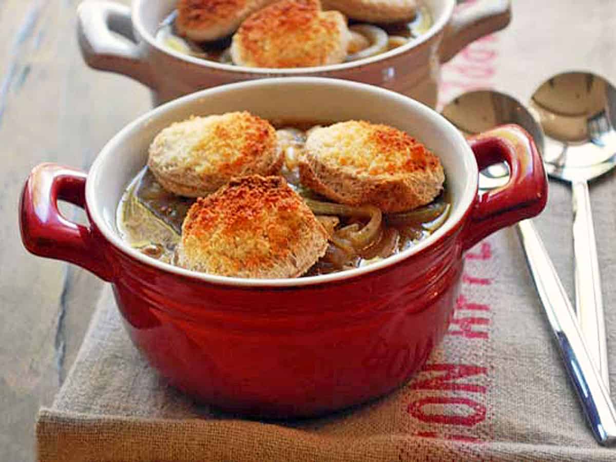 Onion soup is topped with toast rounds.