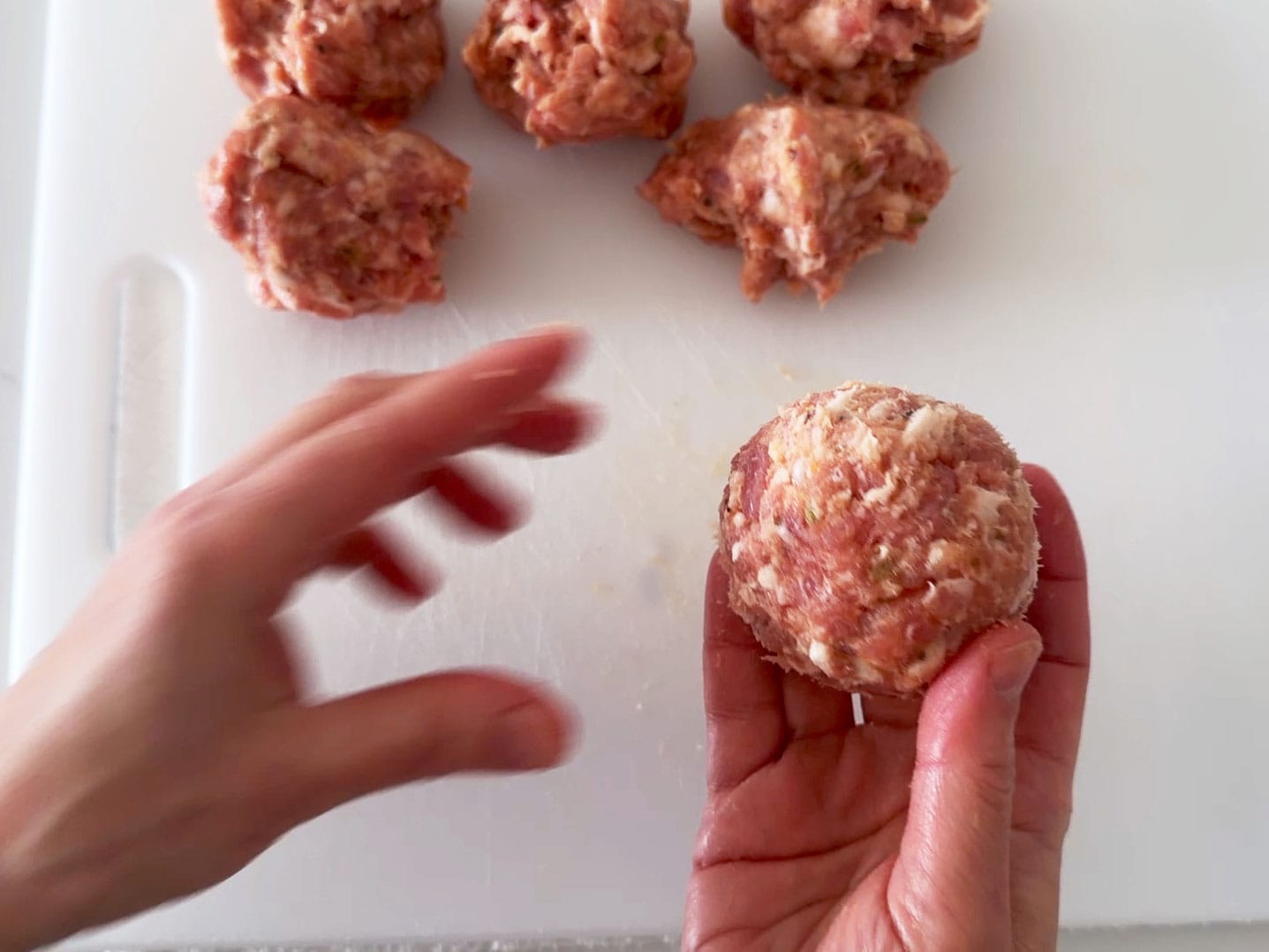 Wrapping the sausage meat around an egg.