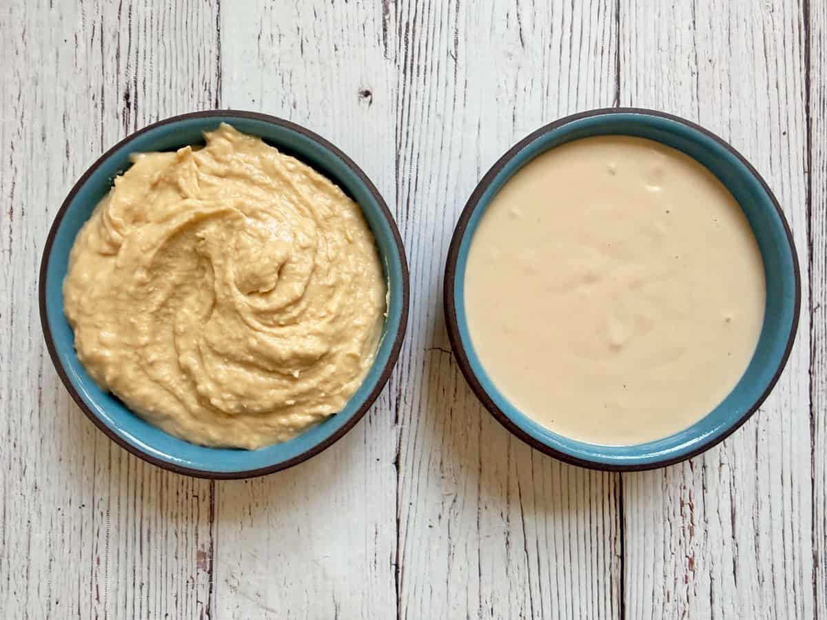 A bowl of tahini sauce next to a bowl of hummus.