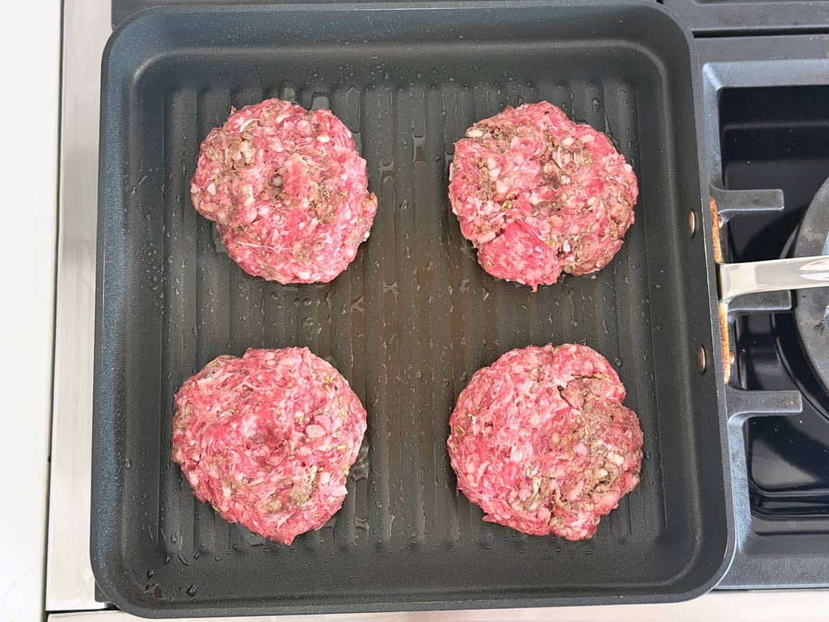 Lamb burgers are cooked in a grill pan.