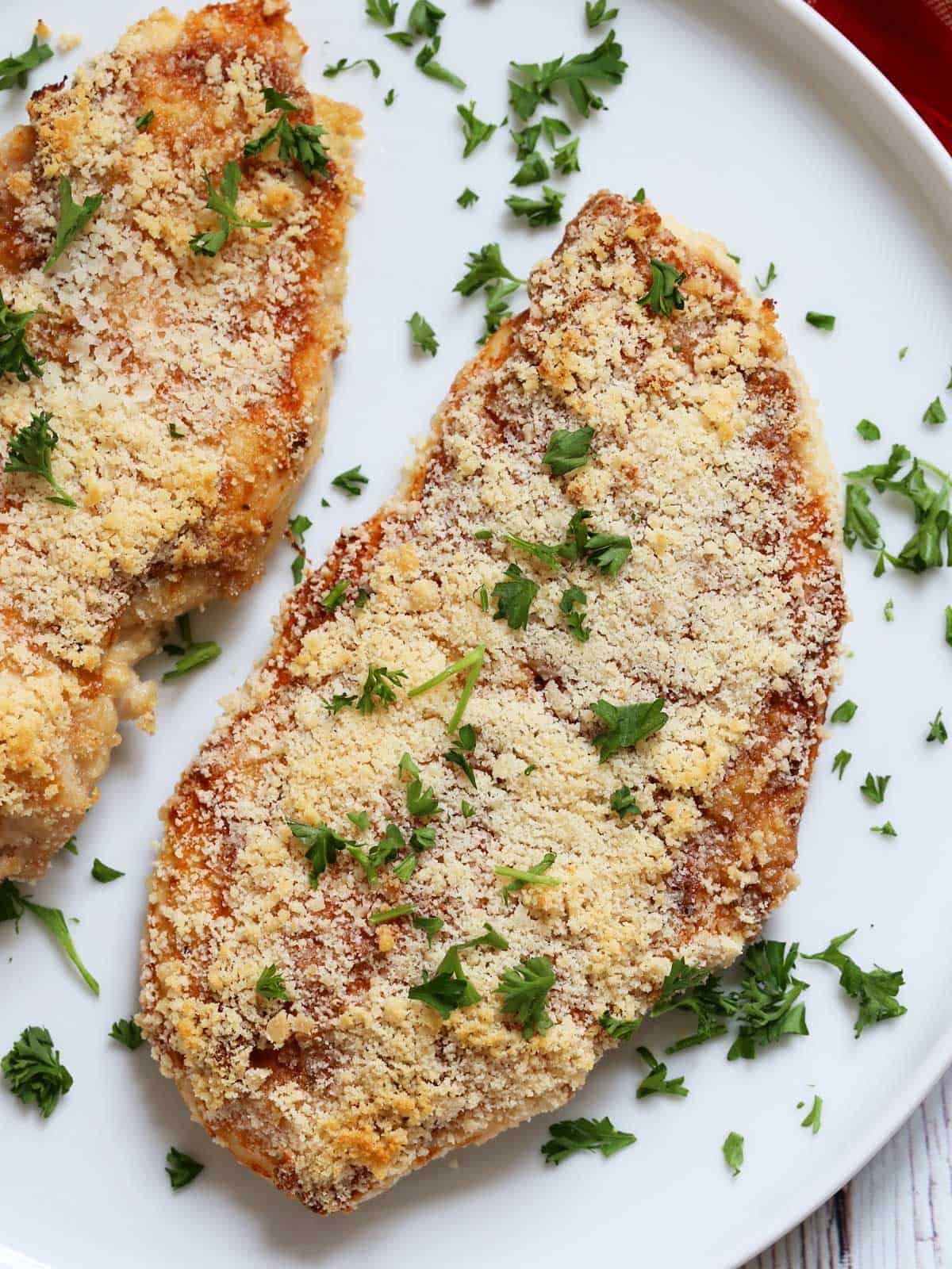 Parmesan crusted chicken is served on a white plate.
